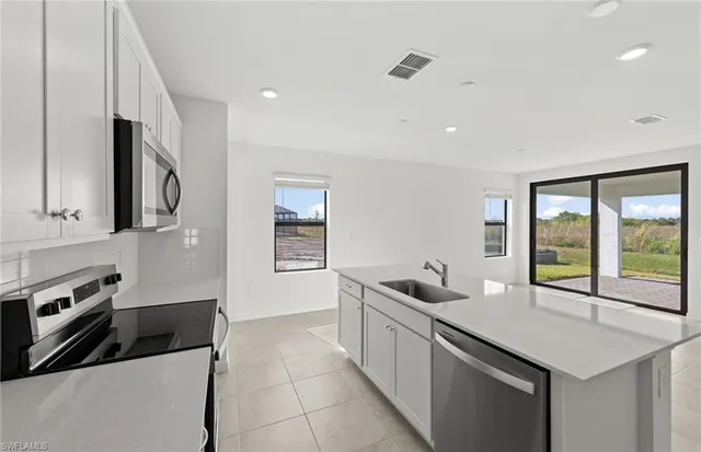 a kitchen with stainless steel appliances a sink a stove and a refrigerator