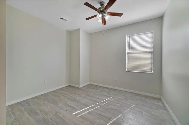 a view of a big room with wooden floor and windows in a room