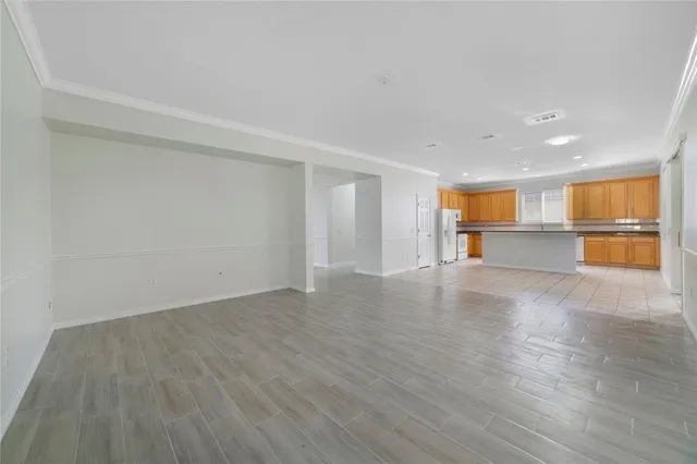 a view of empty room with wooden floor and a window