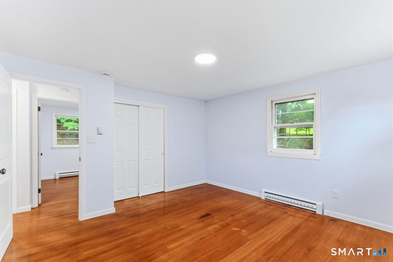 17 Rhoda Lane Bristol, CT 06010 - Photo 10 of 22 a view of an empty room with wooden floor and a window