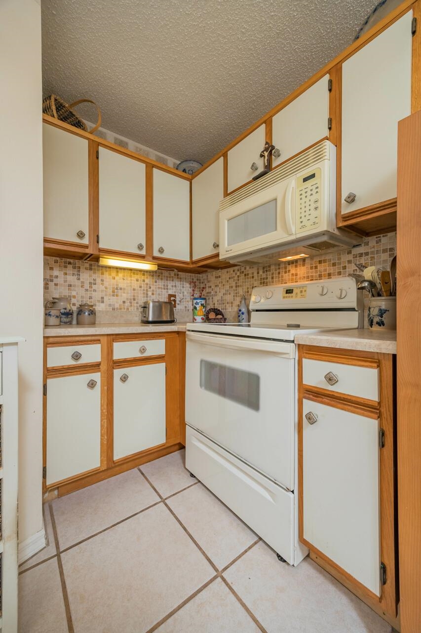 154 Drake Road St. Augustine, FL 32086 - Photo 17 of 36 a kitchen with a stove a sink and white cabinets
