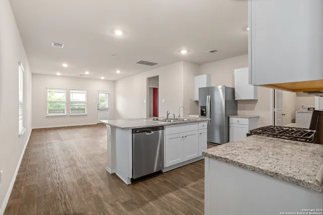 a kitchen with stainless steel appliances granite countertop a sink stove and refrigerator