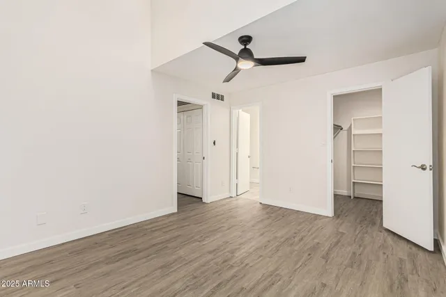 a view of a room with wooden floor and a ceiling fan