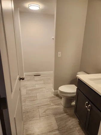 a bathroom with a granite countertop toilet and a sink