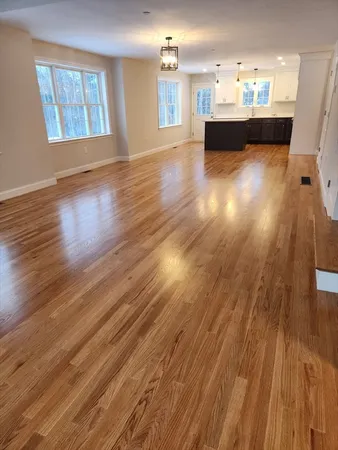 a view of a living room with kitchen view and a fireplace