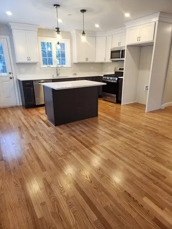 a large kitchen with stainless steel appliances granite countertop a stove and a refrigerator