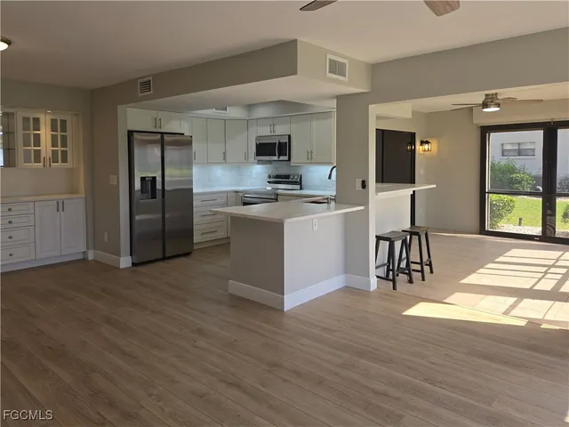 a view of kitchen with sink microwave and refrigerator