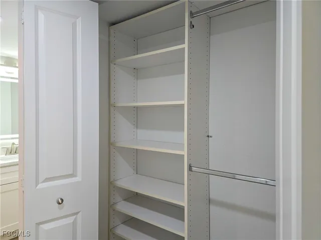 a view of walk in closet with empty racks