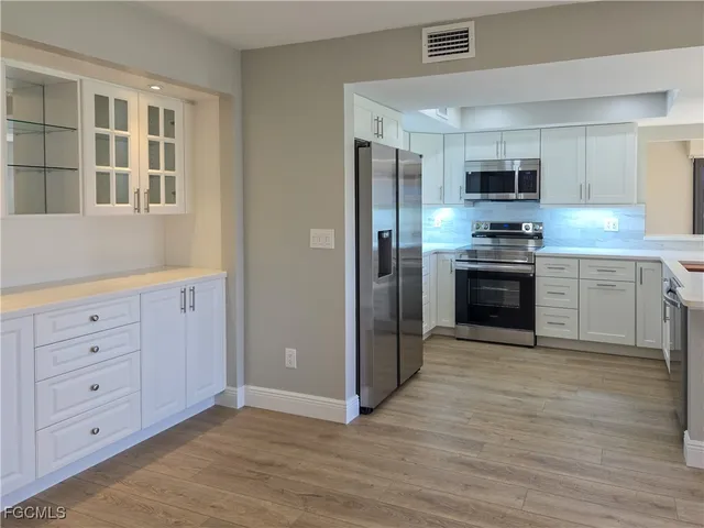 a large kitchen with stainless steel appliances granite countertop a stove and a refrigerator