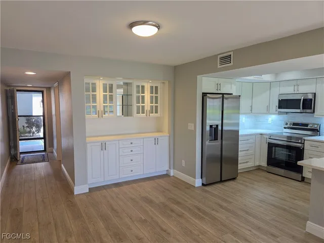 a kitchen with stainless steel appliances a refrigerator and a stove top oven