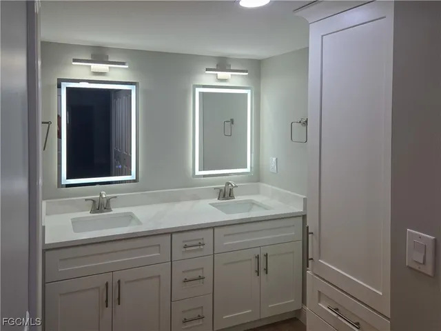 a bathroom with a double vanity sink and mirror