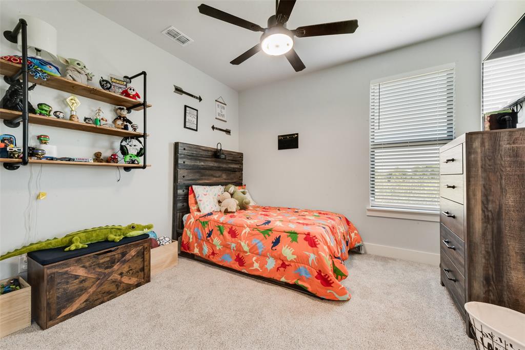 12880 Pruett Road Krum, TX 76249 - Photo 15 of 27 a bedroom with a bed closet and flat tv screen