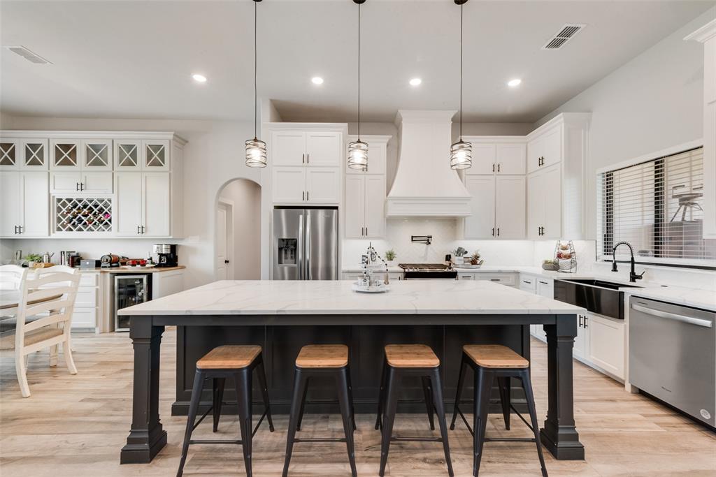 12880 Pruett Road Krum, TX 76249 - Photo 6 of 27 a kitchen with stainless steel appliances kitchen island a table chairs sink and microwave