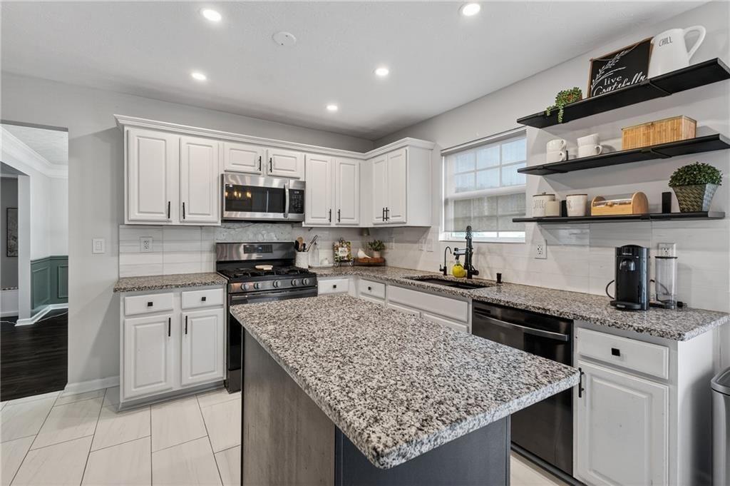 2787 Riders Court Northeast Dacula, GA 30019 - Photo 12 of 26 a kitchen with stainless steel appliances granite countertop a sink stove and refrigerator