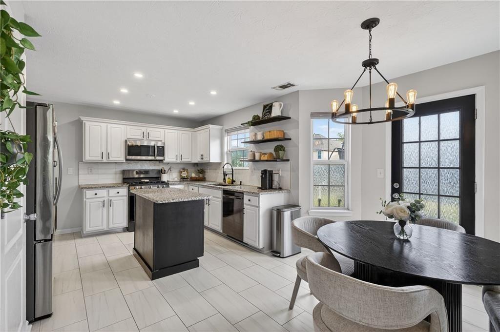 2787 Riders Court Northeast Dacula, GA 30019 - Photo 15 of 26 a kitchen with refrigerator and chairs