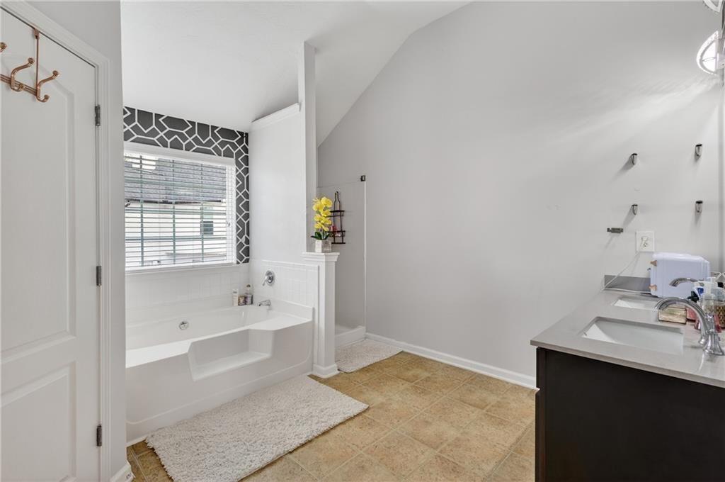 2787 Riders Court Northeast Dacula, GA 30019 - Photo 19 of 26 a bathroom with a bathtub sink and mirror