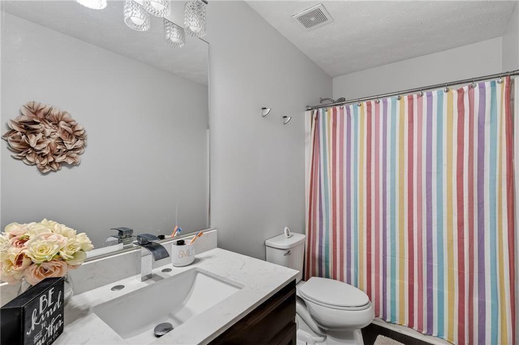 2787 Riders Court Northeast Dacula, GA 30019 - Photo 23 of 26 a bathroom with a sink vanity mirror and toilet