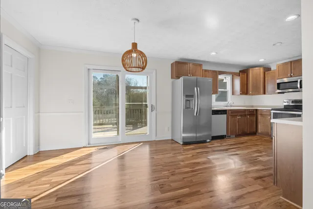 a view of kitchen with stainless steel appliances granite countertop a stove and a refrigerator