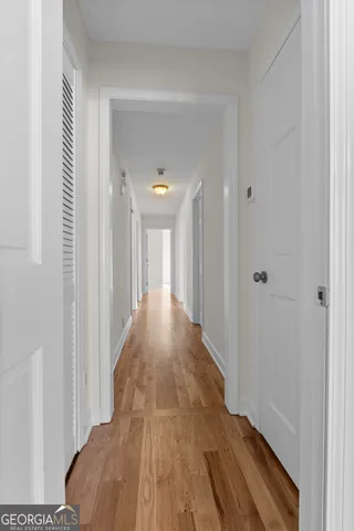 a view of a hallway with wooden floor