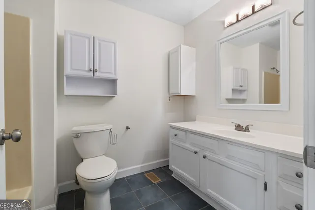 a bathroom with a toilet sink and mirror