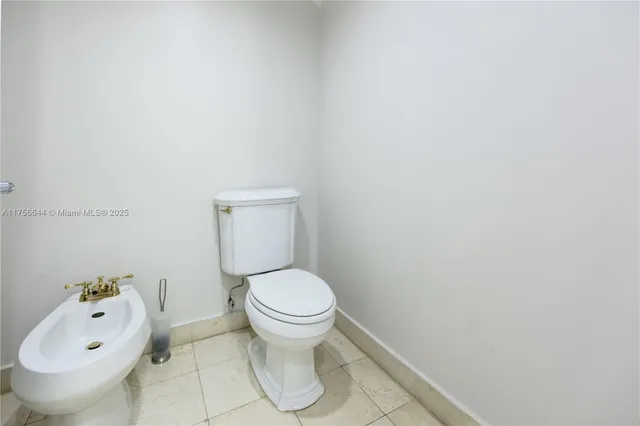 a white toilet sitting next to a white sink and vanity