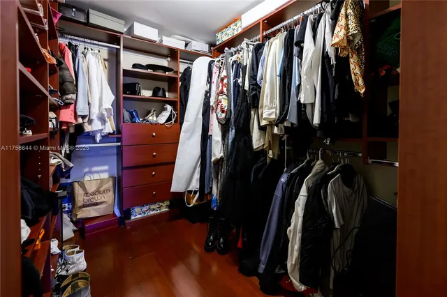 a view of walk in closet with clothes and shoes