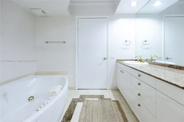 a bathroom with a tub a sink and a mirror