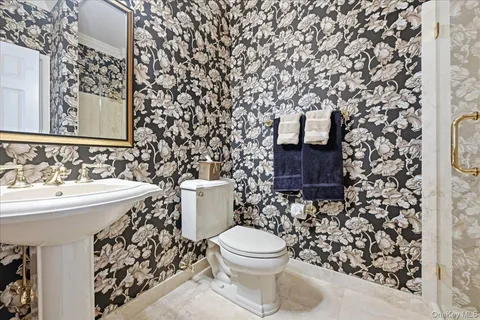 a bathroom with a toilet sink and mirror