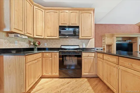 a kitchen with granite countertop white cabinets and stainless steel appliances