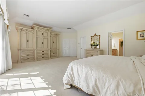 a spacious bedroom with a bed and a dresser