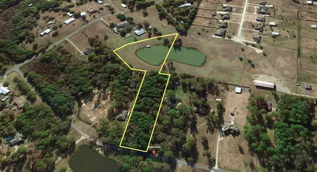 an aerial view of a residential houses with yard