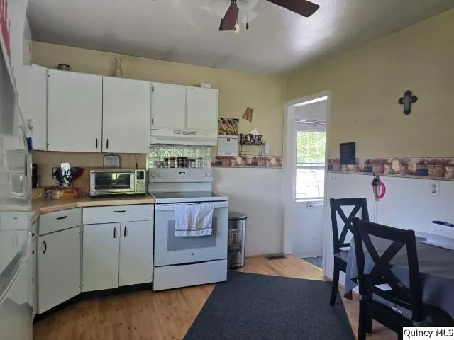 a kitchen with stainless steel appliances granite countertop a stove a sink dishwasher and a refrigerator with wooden floor