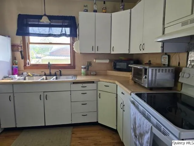 a kitchen with granite countertop white cabinets and a sink