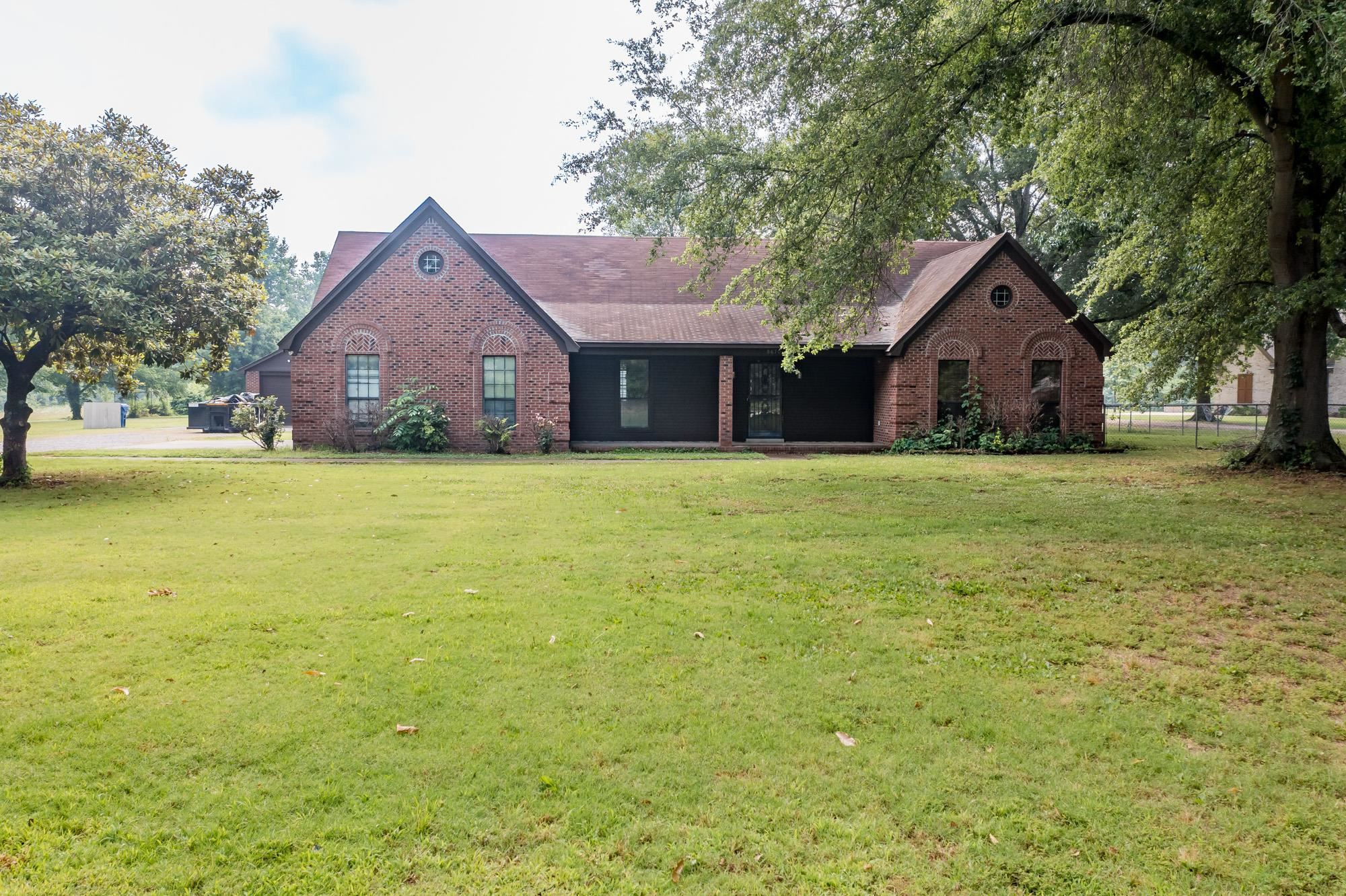a front view of a house with yard and green space