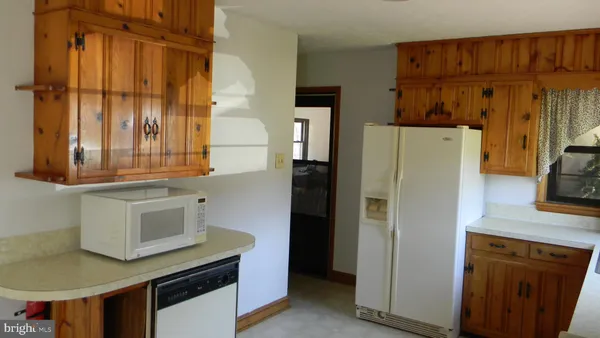 a kitchen with stainless steel appliances granite countertop a refrigerator a stove and a sink with wooden floor