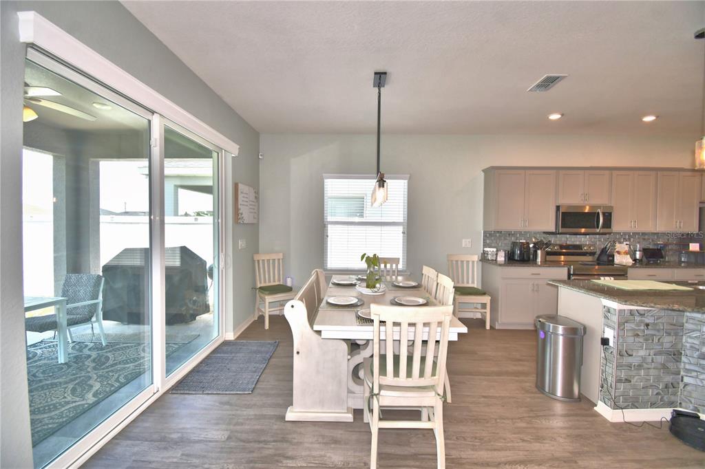 4340 Reding Way Lakeland, FL 33813 - Photo 20 of 63 a view of a dining room with furniture large windows and wooden floor