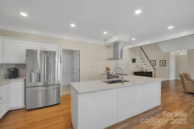 a kitchen with stainless steel appliances granite countertop a sink and a refrigerator