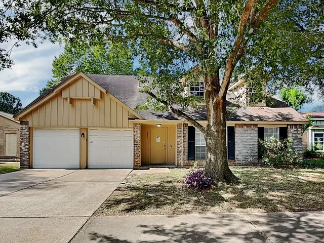 a front view of house with yard and trees around