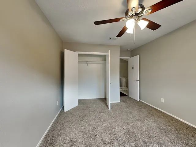 an empty room with chandelier fan