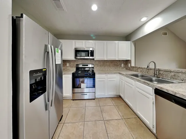 a kitchen with a refrigerator sink and microwave
