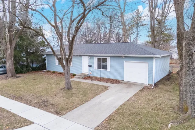a front view of a house with yard and trees