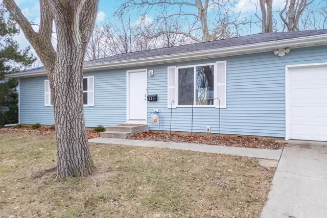 a view of a house with a yard and large tree