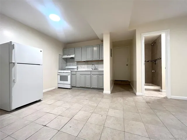 a view of a kitchen with a sink and a refrigerator