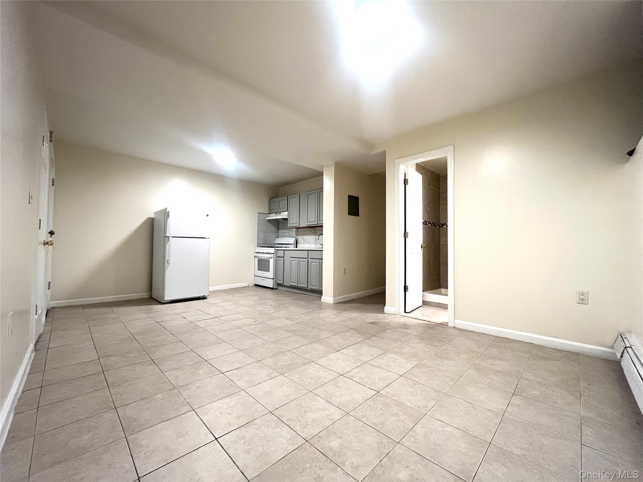 849 Montgomery Street Brooklyn, NY 11213 - Photo 2 of 7 a view of a kitchen with furniture and refrigerator