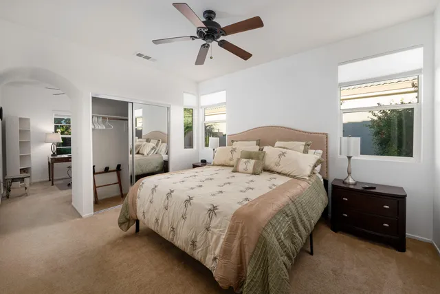a spacious bedroom with a bed and a chandelier