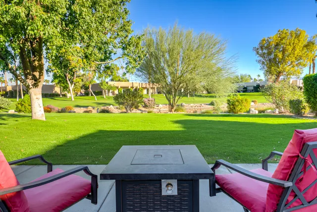 a view of a wooden chairs and table in the garden