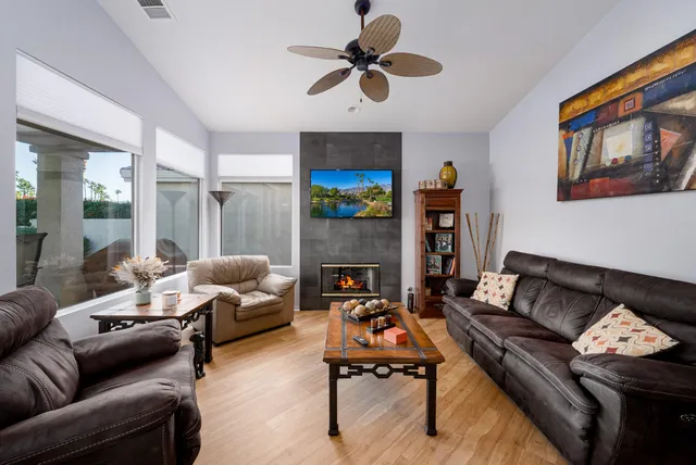 a living room with furniture a fireplace and a flat screen tv
