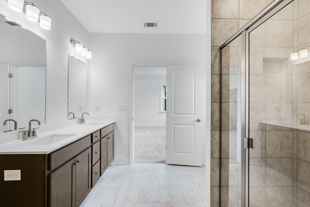 8810 Avonbrook Cl Ball Ground, GA 30107 - Photo 15 of 44 a bathroom with a double vanity sink and mirror