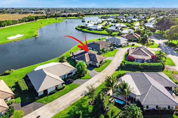 an aerial view of a house with a garden and lake view