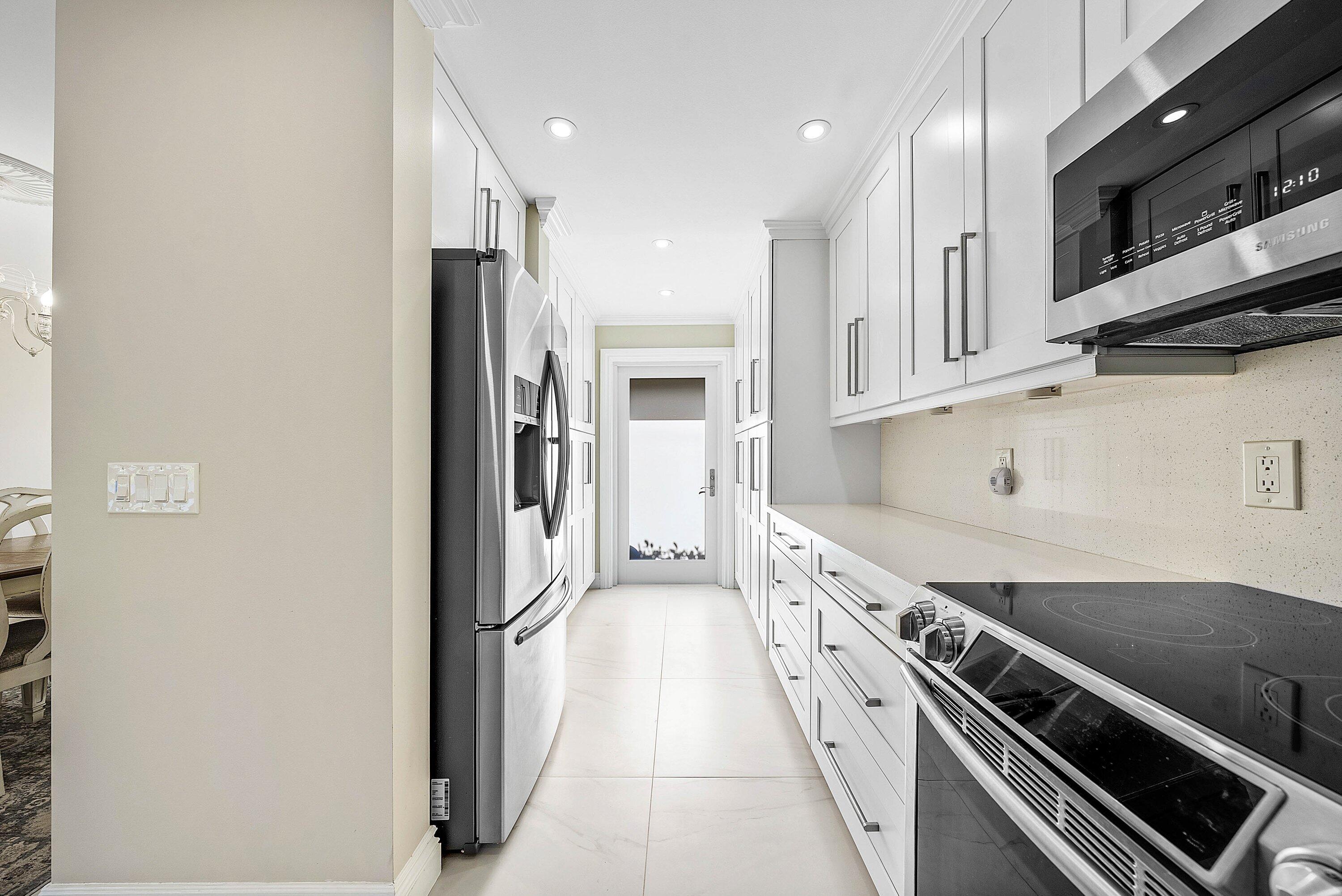 322 Cedar Key Circle Atlantis, FL 33462 - Photo 14 of 55 a large white kitchen with stainless steel appliances